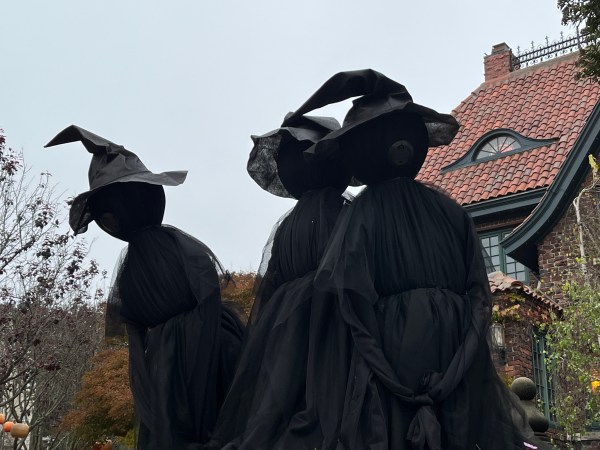 Three souls outside a haunted house celebrating Halloween